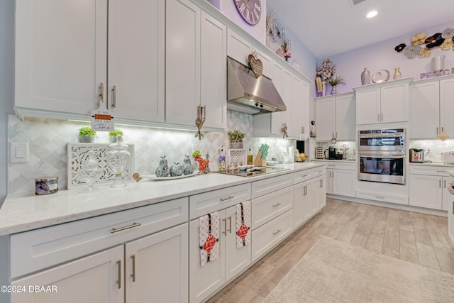 6232 W Fallsgrove Ln, Port Orange, FL 32128 - kitchen with white cabinetry, black electric stovetop, stainless steel double oven, wall chimney range hood, and light wood-type flooring