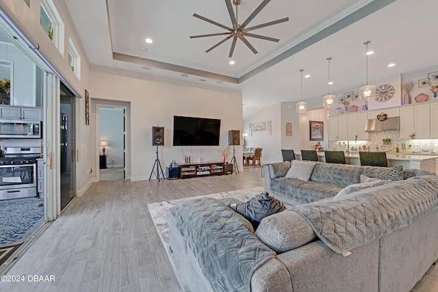 6232 W Fallsgrove Ln, Port Orange, FL 32128 - living room with light hardwood / wood-style floors, ceiling fan, crown molding, and a tray ceiling