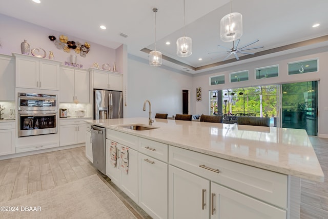 6232 W Fallsgrove Ln, Port Orange, FL 32128 - kitchen with white cabinetry, appliances with stainless steel finishes, decorative light fixtures, a kitchen island with sink, and decorative backsplash