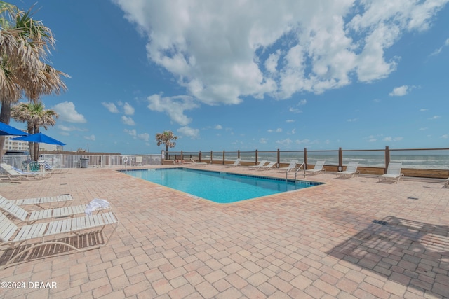 view of swimming pool featuring a patio area and a water view