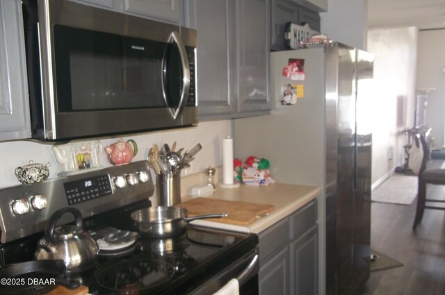 1101 Monticello Ln Unit 3, Port Orange, FL 32129 - kitchen featuring range, stainless steel microwave, light countertops, gray cabinets, and wood finished floors
