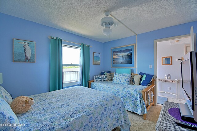 bedroom featuring a textured ceiling, light carpet, and ceiling fan