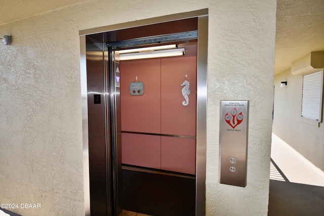 room details featuring elevator and a textured ceiling