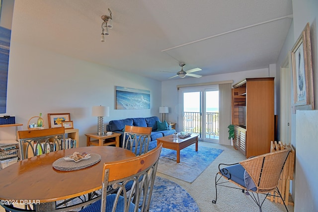 carpeted dining area featuring a textured ceiling and ceiling fan