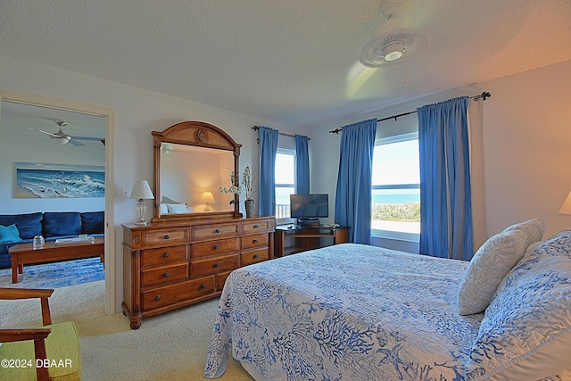 carpeted bedroom featuring a textured ceiling and ceiling fan