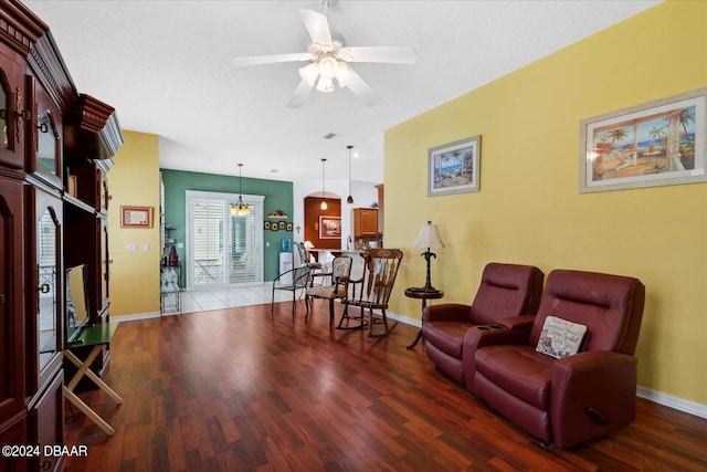 living room with hardwood / wood-style flooring and ceiling fan with notable chandelier