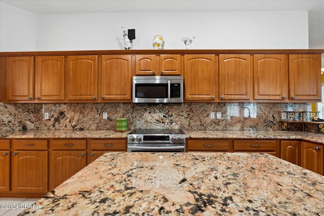 2 Elliot Pl, Palm Coast, FL 32164 - kitchen with stainless steel appliances, light stone counters, and decorative backsplash