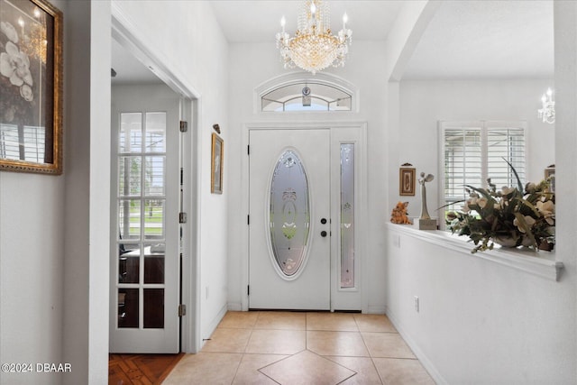 tiled foyer entrance featuring an inviting chandelier