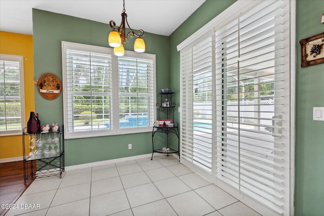 dining room featuring light tile patterned flooring and a notable chandelier