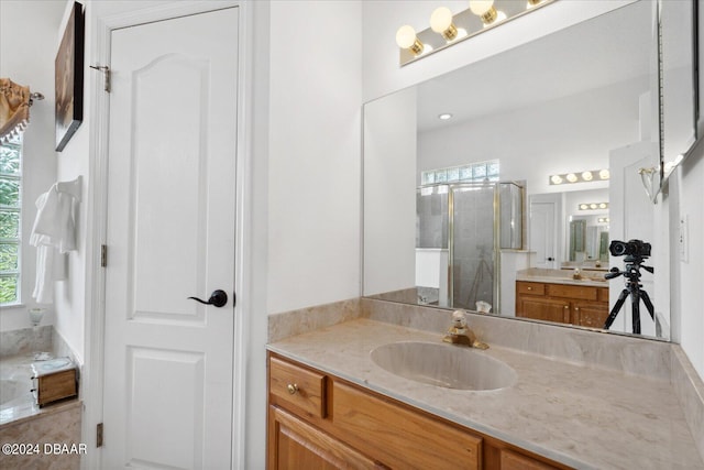 bathroom with an enclosed shower, vanity, and a wealth of natural light