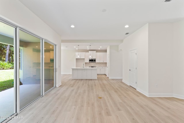 unfurnished living room featuring light hardwood / wood-style flooring and sink