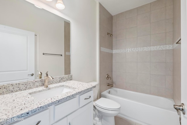 full bathroom with tiled shower / bath, vanity, and toilet