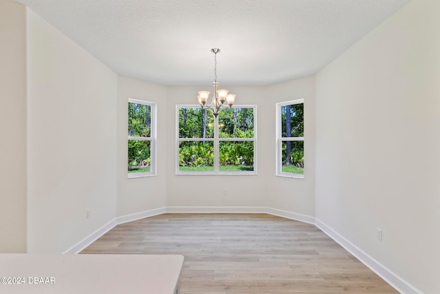 empty room featuring light hardwood / wood-style floors and an inviting chandelier