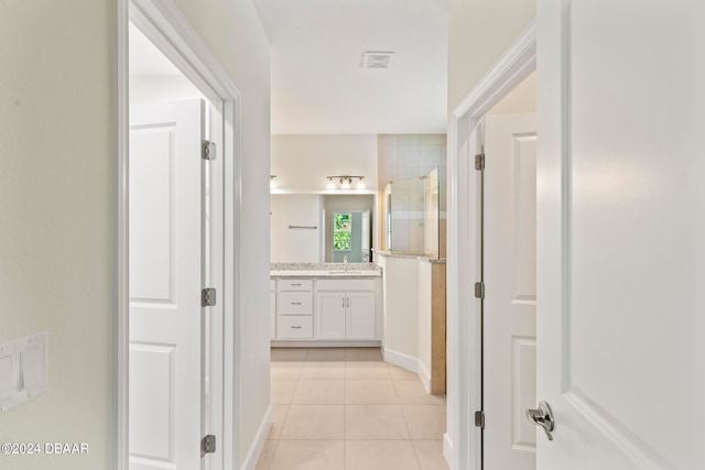 corridor with light tile patterned flooring and sink