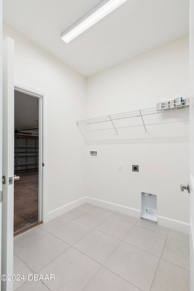 laundry area with hookup for an electric dryer, hookup for a washing machine, and light tile patterned flooring