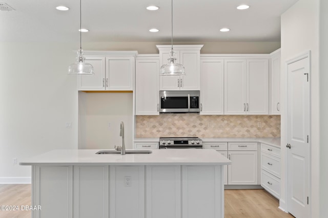 kitchen featuring white cabinetry, stainless steel appliances, sink, and an island with sink