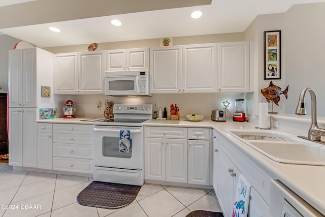 kitchen featuring white cabinets, sink, white appliances, and light tile patterned floors