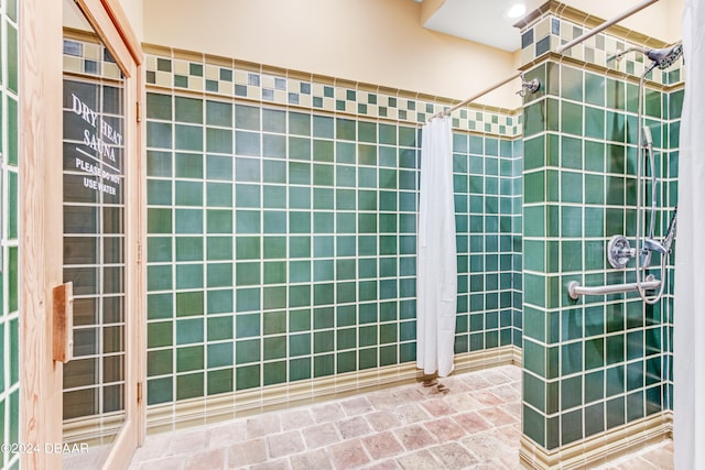 bathroom with a shower with curtain and tile walls