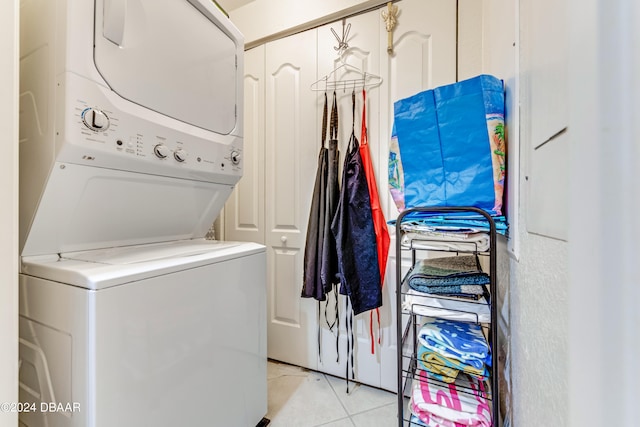 washroom featuring stacked washer and clothes dryer and light tile patterned floors