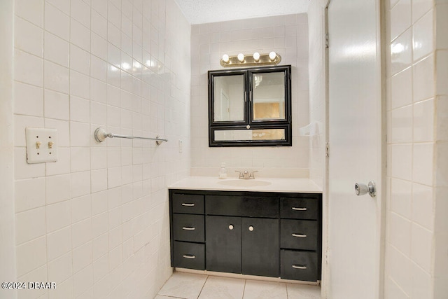 bathroom with tile walls, tile patterned flooring, and vanity