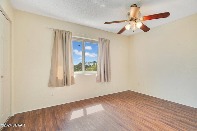 empty room with hardwood / wood-style floors, ceiling fan, and a textured ceiling