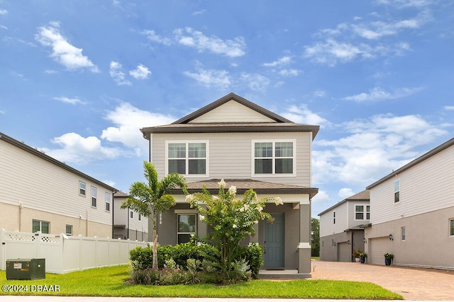 front of property featuring a front yard and a garage