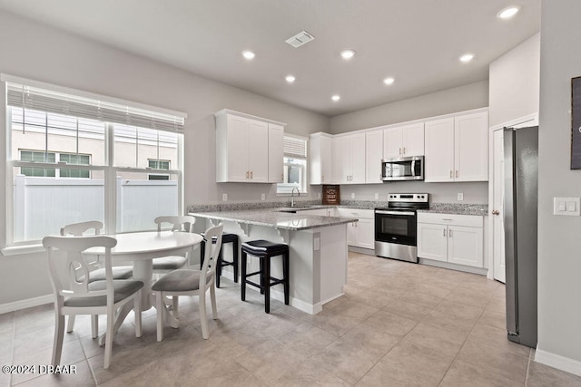 kitchen with white cabinets, sink, kitchen peninsula, and stainless steel appliances