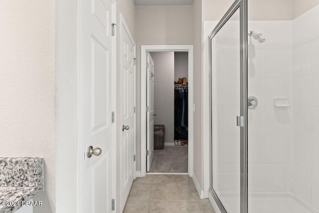 bathroom with tile patterned floors and a shower with door