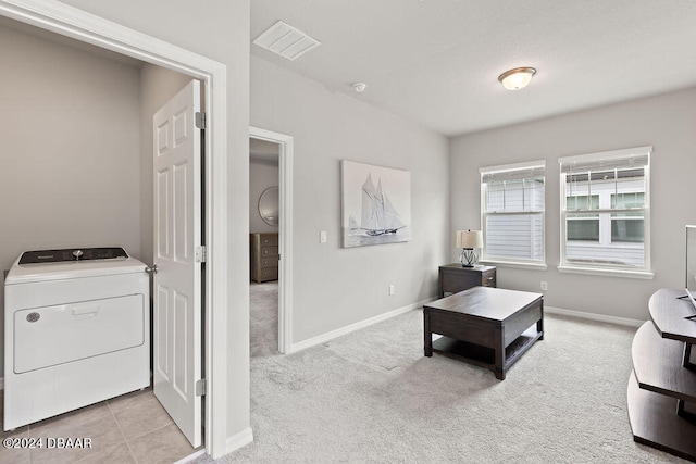 carpeted living room featuring washer / dryer