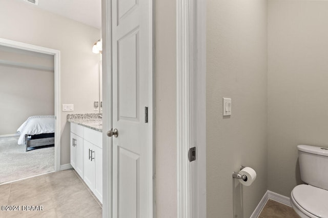 bathroom featuring tile patterned flooring, vanity, and toilet