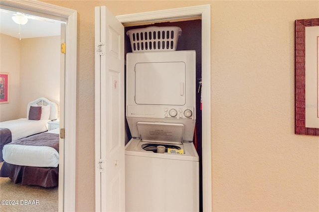 laundry room with stacked washer and clothes dryer and carpet