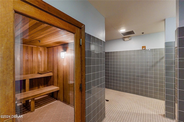 bathroom with tile walls, tile patterned flooring, and wood walls