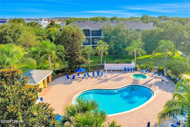 view of swimming pool featuring a hot tub and a patio