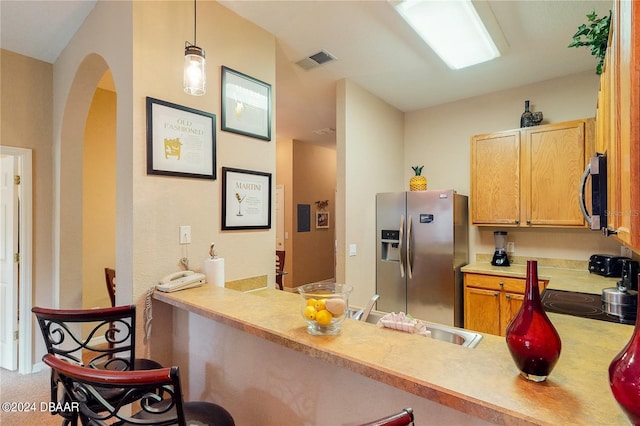 kitchen featuring stainless steel appliances, sink, kitchen peninsula, carpet, and hanging light fixtures