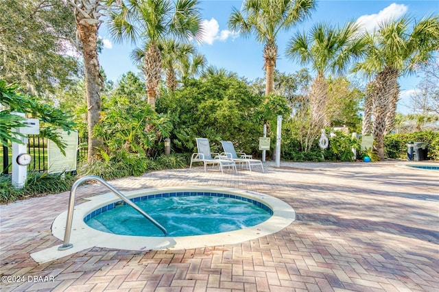 view of swimming pool featuring a patio and a hot tub