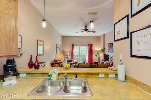 kitchen featuring pendant lighting, light brown cabinets, sink, and ceiling fan