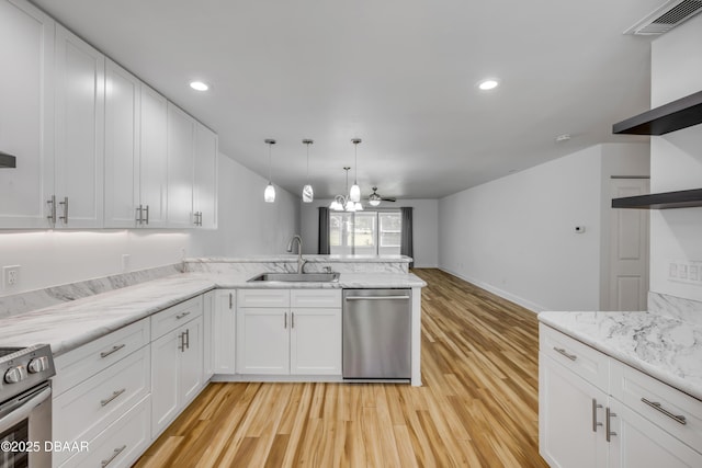 kitchen with appliances with stainless steel finishes, a sink, light wood-type flooring, a peninsula, and white cabinets