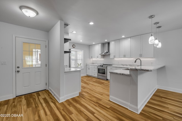 kitchen with stainless steel electric range oven, wall chimney range hood, a peninsula, baseboards, and recessed lighting