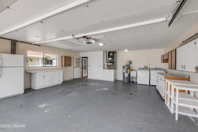 garage with freestanding refrigerator, separate washer and dryer, electric water heater, a garage door opener, and a sink