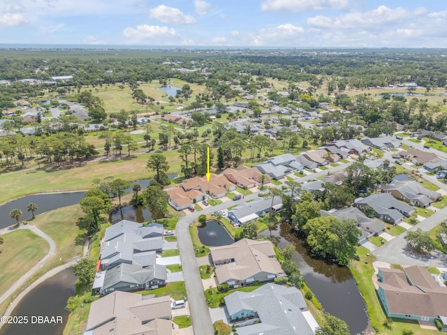 aerial view of property and surrounding area with nearby suburban area, a large body of water, and a golf course
