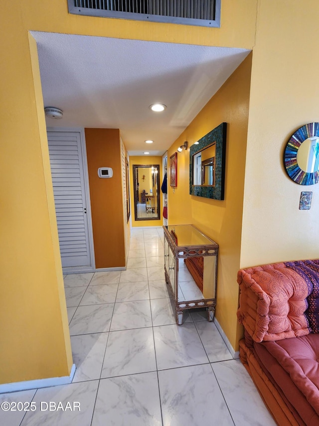 hall featuring a textured ceiling