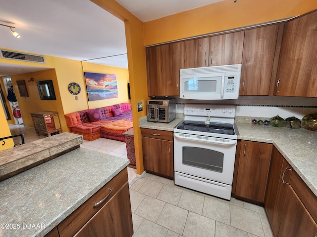 kitchen with light tile patterned floors and white appliances