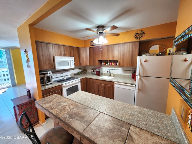 kitchen with light tile patterned flooring, white appliances, ceiling fan, and sink