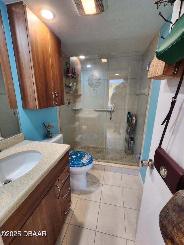 bathroom with toilet, tile patterned flooring, vanity, and walk in shower