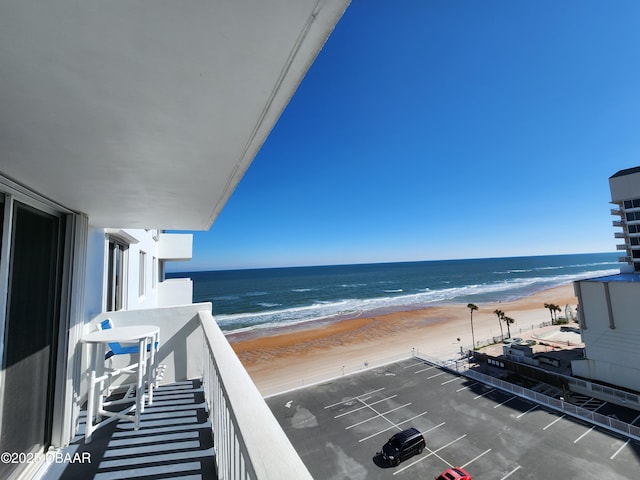 balcony featuring a water view and a view of the beach