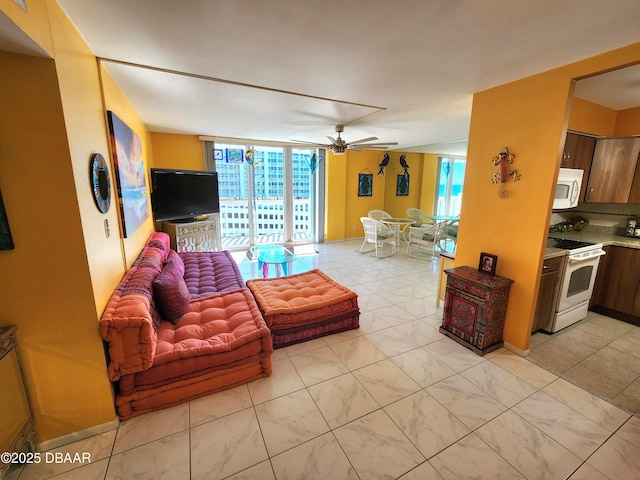 living room featuring ceiling fan and a wall of windows