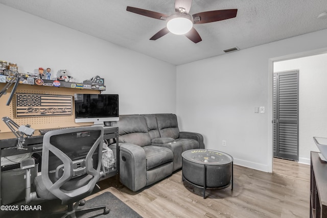 office with ceiling fan, hardwood / wood-style flooring, and a textured ceiling