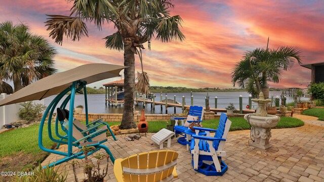 exterior space featuring a water view, a patio, and a boat dock