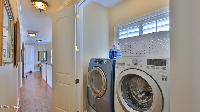 laundry area featuring washing machine and dryer and hardwood / wood-style flooring