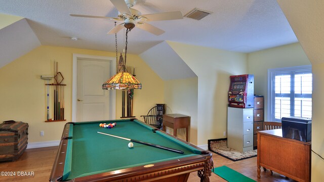 playroom with vaulted ceiling, a textured ceiling, hardwood / wood-style flooring, billiards, and ceiling fan